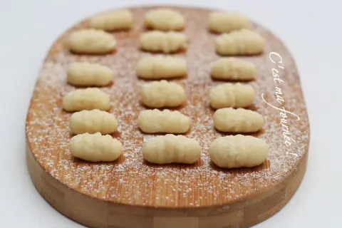 Gnocchis faits maison, une délicieuse pâte italienne à base de pomme de terre, saupoudrés de sucre glace sur une planche en bois.