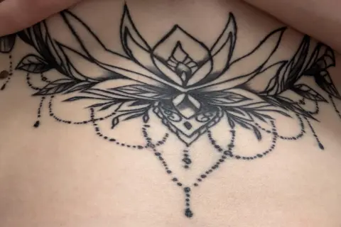 Ein detailliertes Blumen-Tattoo mit zarten Perlenketten. Leider sind einige Linien durch Tattoo Blowout unscharf geworden.