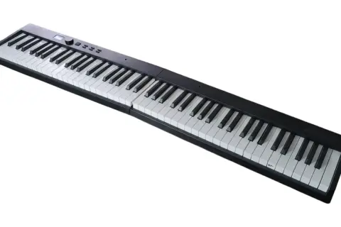 Czarny keyboard z białymi klawiszami, gotowy do zagrania pięknych nut na fortepian.