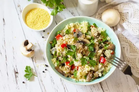 Un gustoso cous cous con funghi, peperoni e prezzemolo fresco. Un piatto leggero e saporito.
