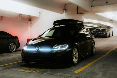 Svart VW Golf med takbox, redo för äventyr. Undrar hur mycket bensin en bil som denna drar?