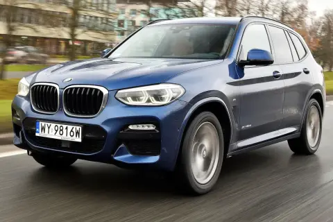 Niebieskie BMW X3 G01 w ruchu. Zastanawiasz się, bmw x3 g01 jaki silnik wybrać? Ten model oferuje wiele opcji.