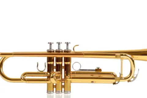 Glänzende goldene Trompete mit drei Ventilen, ein Beispiel für verschiedene Trompeten arten, bereit für musikalische Klänge.