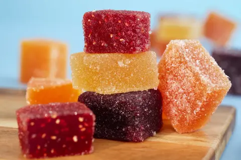 Délicieuses pâtes de fruits fait maison, colorées et enrobées de sucre, prêtes à être dégustées.