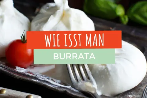 Frische Burrata mit Tomate und Basilikum auf einem Teller. Ein Gabel liegt daneben. Der Text "Wie isst man Burrata" ist eingeblendet.