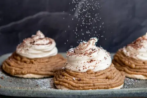 Deliciosas tartas Mont Blanc con crema batida y espolvoreadas con azúcar glas y cacao.