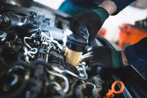 Mechanik wymienia filtr paliwa. Objawy jego zużycia mogą być różne, od spadku mocy po problemy z uruchomieniem silnika.