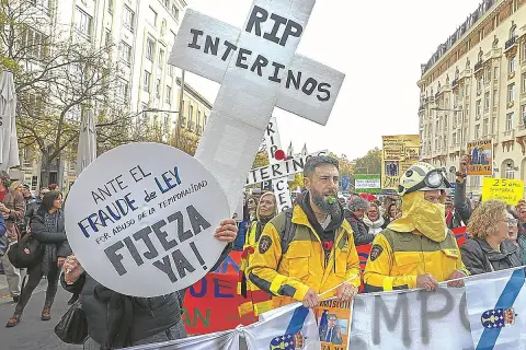 Manifestantes protestan contra el fraude de ley y el abuso de temporalidad, exigiendo fijeza. Un cartel en forma de cruz dice "RIP INTERINOS", reflejando el deseo de no ser interino toda la vida.