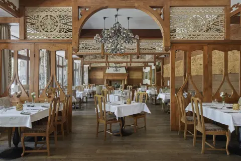 Elegancka restauracja w hotelu 5 gwiazdkowym, z drewnianymi zdobieniami i przytulnym kominkiem.