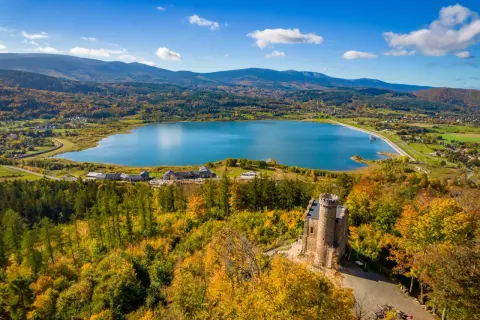 Widok na zamek, jezioro i jesienne Karkonosze.