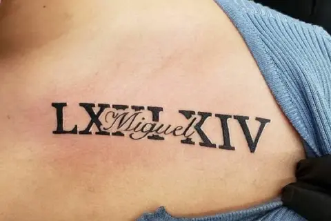 Tatuaż na torsie z rzymskimi cyframi LXIII i XIV, a pośrodku imię "Miguel".