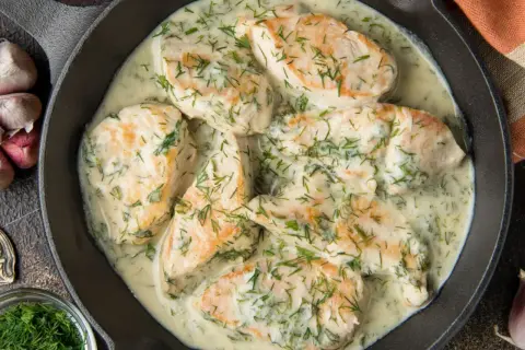 Pyszny kurczak w sosie śmietanowym z koperkiem, podany w żeliwnej patelni. Aromatyczny i kremowy.