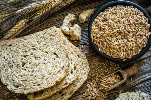 Vollkornbrot mit Dinkel oder Roggen, Körner in einer Schüssel und auf einem Löffel. Gut für Diabetes.