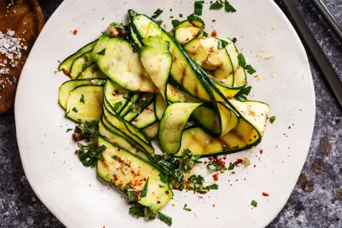 Zucchine grigliate condite con erbe fresche, aglio, sale grosso e peperoncino. Un'idea semplice per gustare le zucchine.
