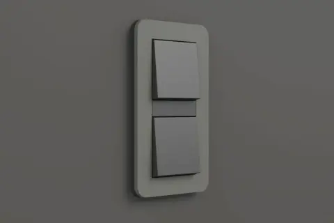 Ein moderner Gira E3 Lichtschalter mit zwei grauen Wippen auf einer hellgrauen Wand.