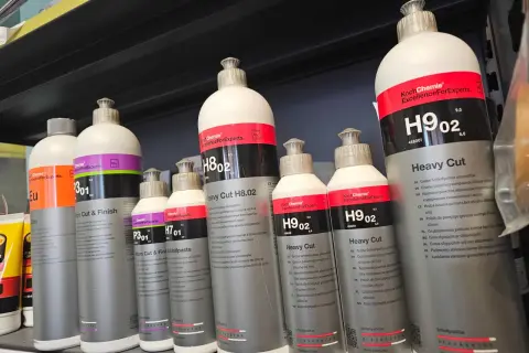 Butelki z pastą polerską Koch Chemie, w tym Heavy Cut H9.02 i Micro Cut & Finish P3.01, stoją na półce.
