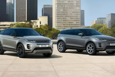 Dwa eleganckie samochody Range Rover stoją na tle nowoczesnej architektury miejskiej.