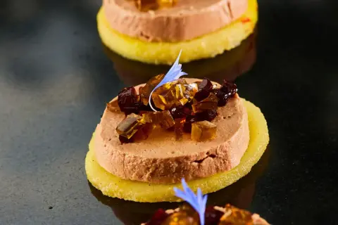 Délicieuse terrine de foie gras sur une tranche d'ananas, garnie de dés de gelée et d'une fleur bleue. Un vrai régal pour savoir comment démouler une terrine de foie gras.