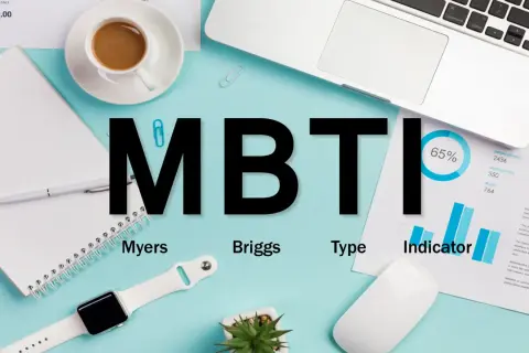 MBTI-Test: Myers-Briggs-Typen-Indikator. Ein Schreibtisch mit Laptop, Notizbuch, Kaffee und einem 16 Typen Test.