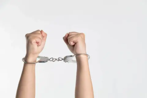 Manos esposadas, símbolo de personas controladoras que buscan limitar la libertad.