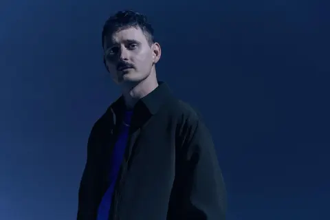 Dawid Podsiadło w granatowej stylizacji, promujący swoje nowe płyty.