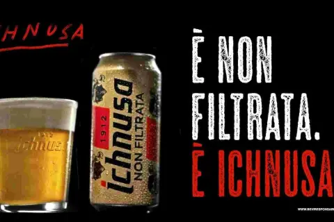 A glass of Ichnusa beer and a can of Ichnusa Non Filtrata beer on a black background.