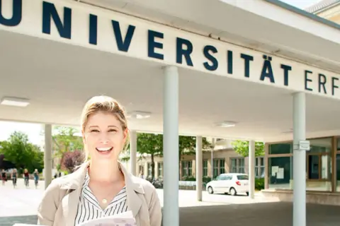 Glückliche Studentin vor der Universität Erfurt. Hier lässt es sich gut studieren!