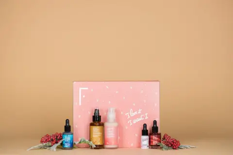 Caja rosa con productos de belleza y bayas rojas. ¡Las **productos freshly opiniones** son excelentes para esta rutina de cuidado de la piel!