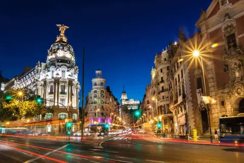 Noche en Gran Vía, Madrid. Edificios iluminados y luces de coches crean un ambiente vibrante. Un lugar ideal que ver en Madrid centro.