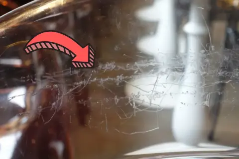 Flèche rouge indiquant des traces de peinture à enlever sur du verre.