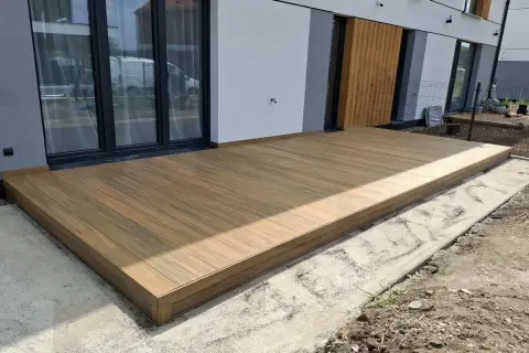 Nowy taras na słupach betonowych, wykonany z desek kompozytowych, stanowi idealne przedłużenie domu.
