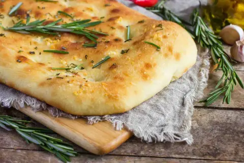 Un pain italien traditionnel, doré et moelleux, garni de romarin frais et d'ail. Parfait pour accompagner un repas.