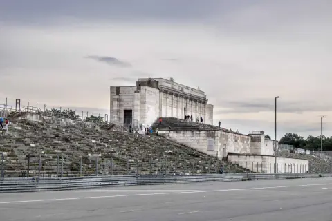 Besucher erkunden die imposanten Steintribünen und das monumentale Gebäude der Nürnberger Reichsparteitagsgelände.