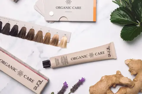 Paleta de color tinte pelo con tonos rubios y castaños. Tubo de coloración permanente y caja de la marca Organic Care.