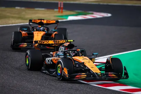 Dos coches de Fórmula 1 de McLaren, con el equipo de Andrea Stella, compiten en una curva.