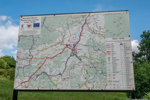 Mapa gminy Milówka pokazuje przebieg niebieskiego szlaku rowerowego. Widać liczne drogi i ścieżki, a także legendę z symbolami.