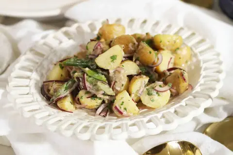En krämig potatissallad med rödlök och örter, ser ut att vara den godaste potatissalladen för en sommarbuffé.