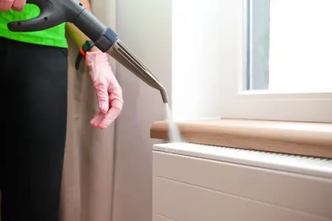 Mit einem Dampfreiniger wird die Heizung gereinigt. Dampf löst Schmutz und Bakterien.