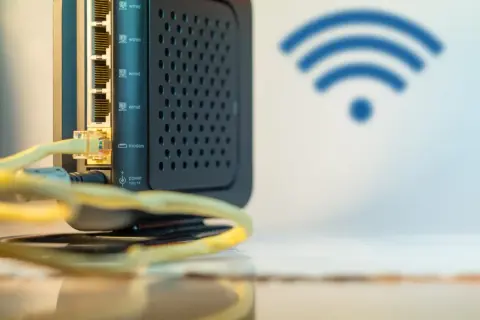 Czarny router z wieloma portami LAN i ikoną Wi-Fi. Ten wzmacniacz internetu zapewnia stabilne połączenie.