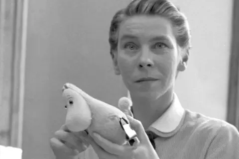 Tove Jansson, autorka książek o Muminkach, trzyma w dłoniach pluszowego Muminka.