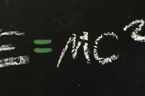 Równanie E=mc² napisane kredą na czarnej tablicy.