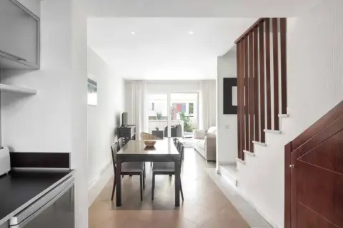 Comedor y sala de estar luminosos con escaleras de madera. Imagina cenar en el restaurante La Buganvilla San José.