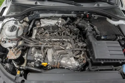 Silnik 1.6 TDI z widocznymi przewodami, filtrem powietrza i zbiorniczkiem płynu chłodniczego.