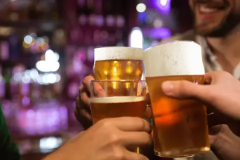 Brindisi con birra in un locale. Forse dopo un bicchiere, la birra fa dormire bene.