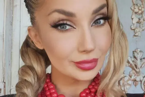 Piękna kobieta z warkoczami i czerwoną koralami. Czy to Cleo?