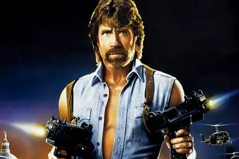 Chuck Norris w akcji, gotów do strzału z dwóch pistoletów maszynowych. Klasyka jego filmów akcji.