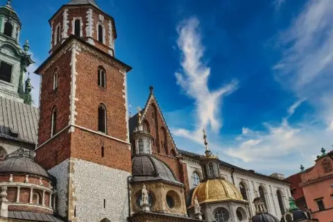 Wawel w Krakowie, idealne miejsce na darmowe wydarzenia. Zobacz majestatyczne wieże i złote kopuły na tle błękitnego nieba.