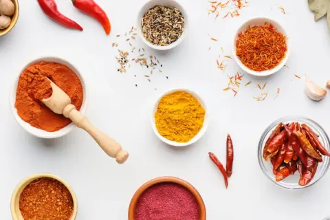 Miseczki z przyprawami: papryka, kurkuma, szafran, chili. Ile procent ostrości w tej warkocze czerwonej?