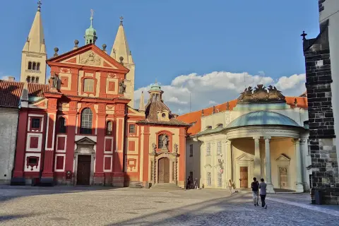 Visite à Prague : la place pavée devant la basilique Saint-Georges et le monastère, avec des touristes se promenant sous un ciel bleu.