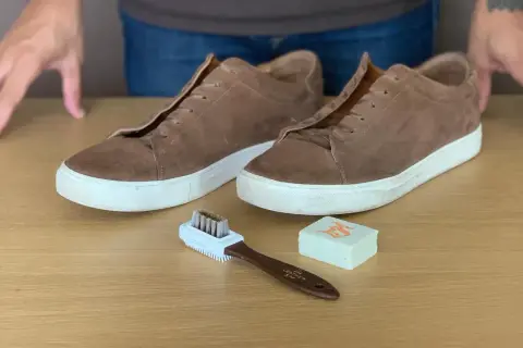 Paire de baskets en cuir marron clair, brosse et gomme pour apprendre comment nettoyer des chaussures en cuir marron clair.